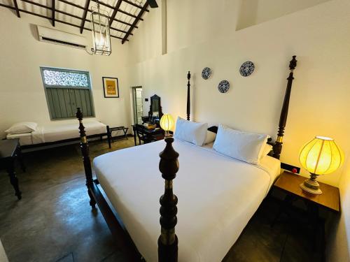 a bedroom with a large bed and a living room at Moi Talpe by DBI in Talpe