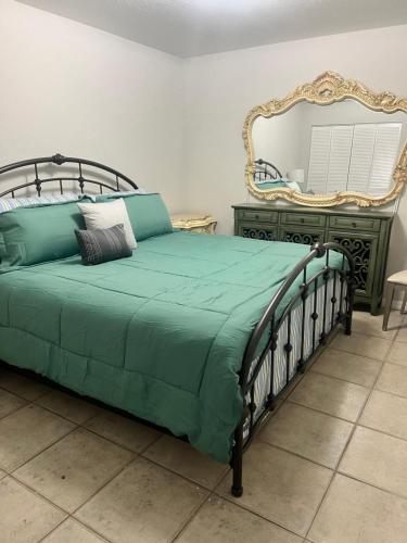 een slaapkamer met een bed met een spiegel en een dressoir bij Kp Paradise in North Miami