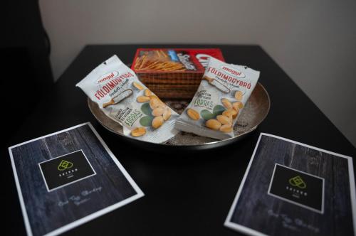 a table with two pamphlets and a bowl of food at Perle Vendégház in Kesztölc