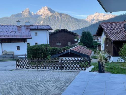 un grupo de edificios con montañas en el fondo en Bergerwachen en Berchtesgaden