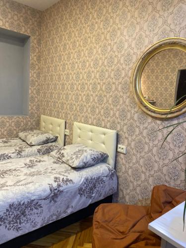 a bedroom with two beds and a mirror at Anna'S Home in Kutaisi