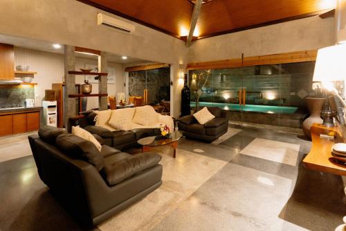 a living room with two couches and a table at Bracha Villas Bali - CHSE Certified in Seminyak