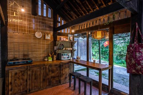una cocina con armarios de madera, mesa y sillas en La Maison SAPA en Sa Pả