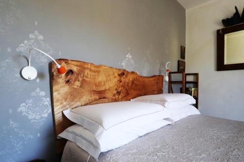 a bedroom with two beds and a wooden headboard at B&B Tricudai in Agliano Terme