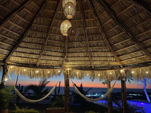 a large straw umbrella with lights on a beach at Bungalow Ballena c/vistas increíbles al Océano Pacífico in Perihuete