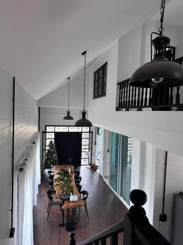 una grande stanza con un lungo tavolo e sedie di บ้านสมดุลมิตร Hidden Private White Brick House Rayong a Rayong