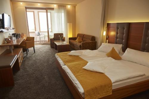 a bedroom with a large bed and a living room at Flair Hotel zum Schiff in Meersburg