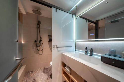 een badkamer met een wastafel, een toilet en een spiegel bij 琴笙酒店 in Xiamen