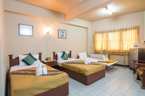 a hotel room with two beds in a room at Khelang Nakorn Hotel in Lampang