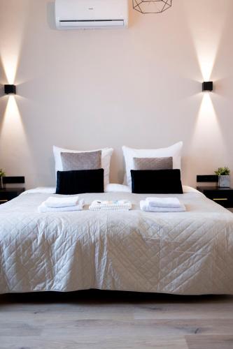 a bedroom with a large white bed with two pillows at Grand Central Suites in Zandvoort