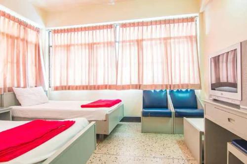 a hotel room with two beds and a tv at Khelang Nakorn Hotel in Lampang