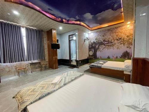 Hoàng Gia Hotel - 1224 CMT8 Bình Dương - by Bay Luxury في Ấp Phú Thọ: غرفة نوم مع سرير و لوحة على السقف