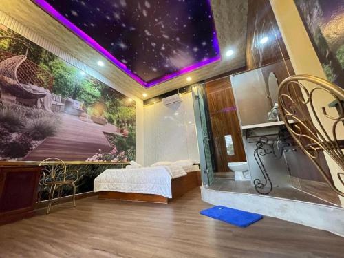 Hoàng Gia Hotel - 1224 CMT8 Bình Dương - by Bay Luxury في Ấp Phú Thọ: غرفة بسرير ودهان على الحائط