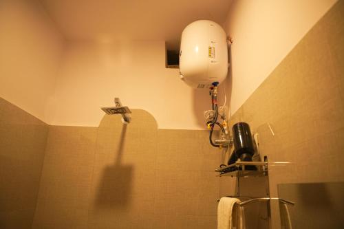 a bathroom with a toilet with a hair dryer on the wall at Hotel Mystic Mithila in Janakpur