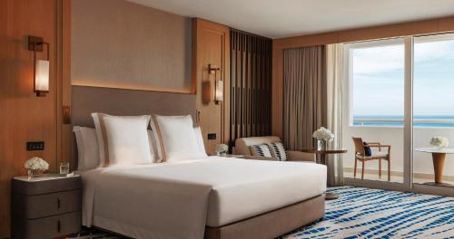 a hotel room with a large bed and a large window at Jumeirah Beach Hotel in Dubai