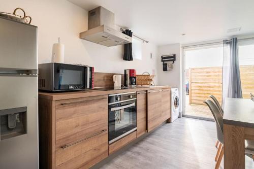a kitchen with a microwave and a stove top oven at maison proche Disneyland , parc des Félins et Coulommiers in Saint-Augustin