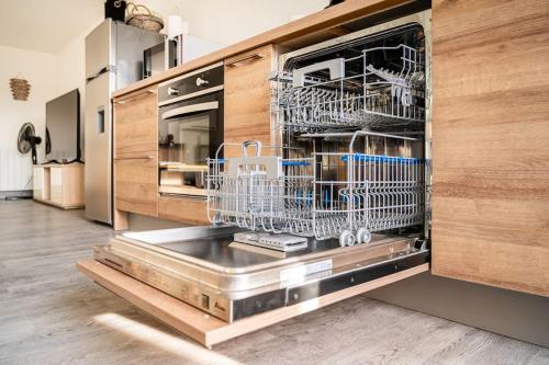 a kitchen with dishes in a dishwasher at maison proche Disneyland , parc des Félins et Coulommiers in Saint-Augustin