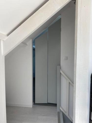 a hallway of a white building with an open door at maison proche Disneyland , parc des Félins et Coulommiers in Saint-Augustin