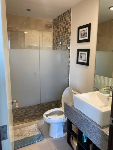 a bathroom with a shower and a toilet and a sink at Bonito departamento pie de playa en el mejor condominio de manzanillo, Ponto Horizonte. Hermosa vista, hasta para 8 personas. Ambiente familiar. in Manzanillo