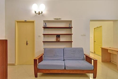 um sofá azul num quarto com duas portas em Krida Inn em Chennai