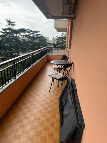 einen Balkon mit einem TV sowie einem Tisch und Stühlen in der Unterkunft Casa al mare in Cogoleto