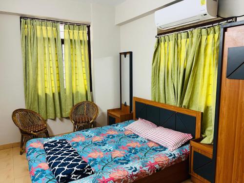 um quarto com uma cama e 2 cadeiras em Royal Home Stay em Patna
