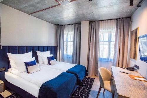 ein Hotelzimmer mit einem großen Bett und einem Schreibtisch in der Unterkunft Hotel M23 Katowice in Kattowitz