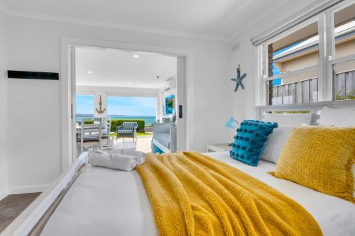 a bedroom with a bed with yellow and blue pillows at Talisman Ocean views in Portland