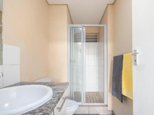 a bathroom with a sink and a toilet and a shower at Leas Furnished Apartments - Capital Hill in Pretoria