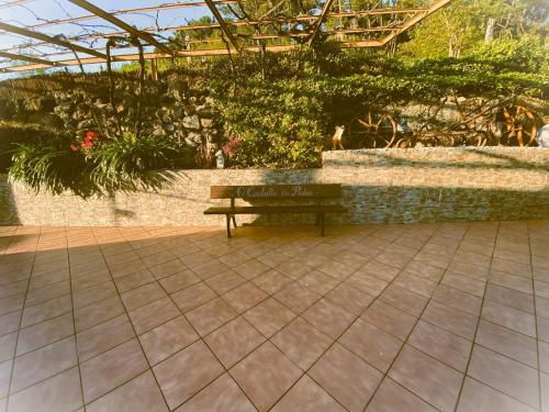 a bench in a garden with a stone wall at Casa rural O CARBALLO DA PEDRA in La Cañiza