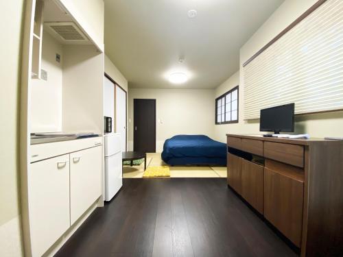 a kitchen with white cabinets and a blue bed at 伏見稲荷相深 in Kyoto