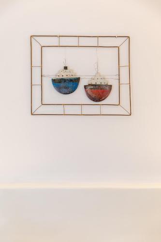 two glass boats hanging on a wall at Nikolas Hotel in Karterados
