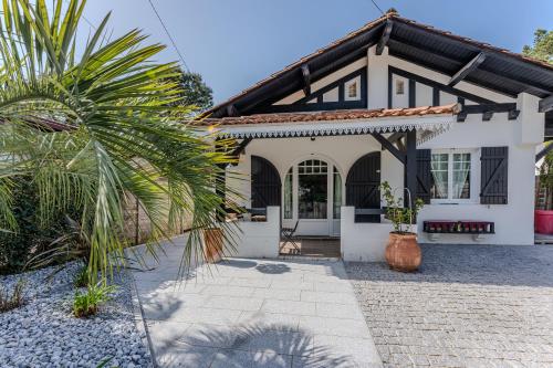une maison avec un palmier devant dans l'établissement Villa AMAYA, Pyla/ Le Moulleau, à La Teste-de-Buch