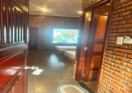 un couloir avec une chambre dotée d'un canapé et d'une fenêtre dans l'établissement Wild Beach Boutique Resort, à Ninh Phuoc