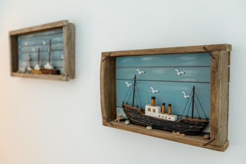 a model of a ship in a wooden frame on a wall at Nikolas Hotel in Karterados