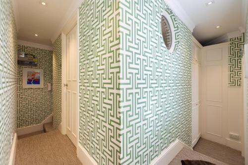 un pasillo con una pared estampada en verde y blanco en A Royal Residence – Stylish 2 Bedroom in Kensington en Londres