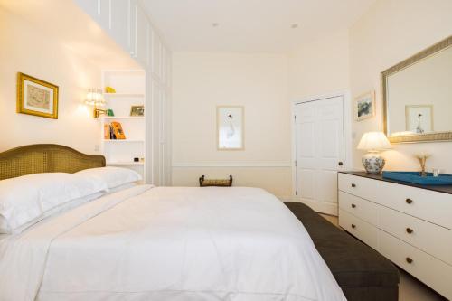 um quarto branco com uma cama grande e um espelho em Traditional Treasure – 3 Bedroom Home by Hyde Park em Londres