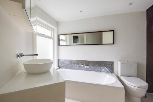 Baño blanco con lavabo y aseo en Luxury and Cool 2 bedroom in Notting Hill en Londres