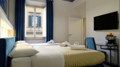 ein Hotelzimmer mit 2 Betten und einem Fenster in der Unterkunft Residenza San Lorenzo Firenze in Florenz