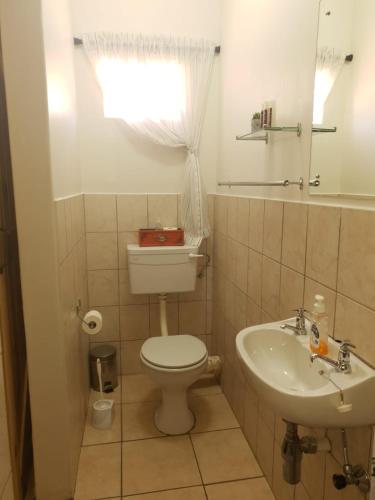 a bathroom with a toilet and a sink at Tehillah Guesthouse in Upington