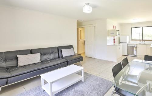 a living room with a black couch and a table at Mildura Holiday Villas in Mildura