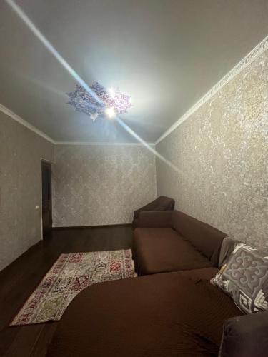 salon z kanapą i sufitem w obiekcie Квартира w mieście Szymkent