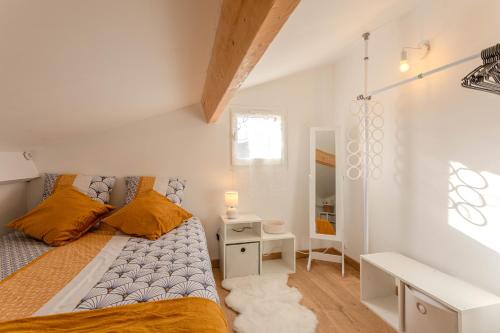 Dormitorio pequeño con cama y espejo en Joli Mazet indépendant, en La Motte