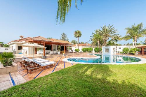 a backyard with a swimming pool and a house at Exclusive Home Maspalomas in San Bartolomé