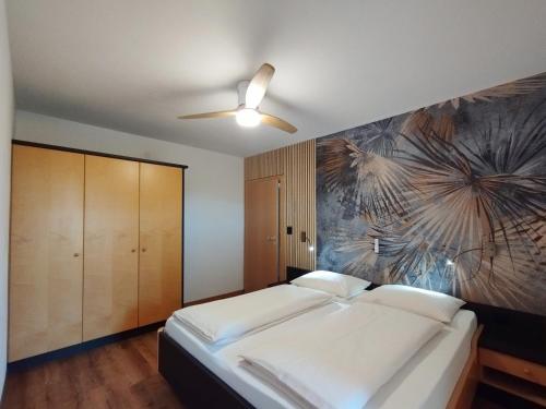 1 dormitorio con 1 cama y una pintura en la pared en Ferienwohnungen Braiter, en Rifiano