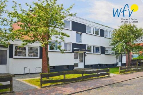 an exterior view of a white and blue building at Haus am alten Leuchtturm Ferienwohnung 16 in Wangerooge