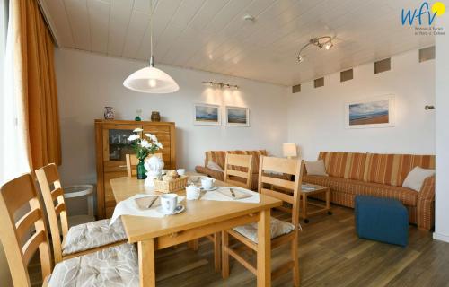 une salle à manger et un salon avec une table et des chaises dans l'établissement Haus am alten Leuchtturm Ferienwohnung 8, à Wangerooge