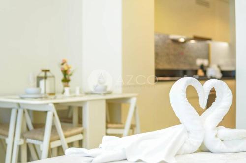 un par de cisnes blancos sentados en la parte superior de una cama en Elegant Studio at Aykon City Tower - C, en Dubái