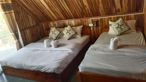 two beds with stuffed animals on them in a room at Amphai Guest house in Nongkhiaw