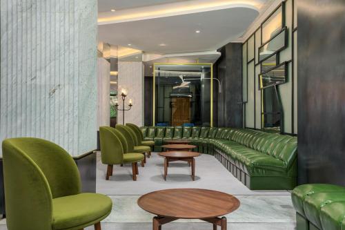 a waiting room with green couches and tables at Le Meridien Batumi in Batumi